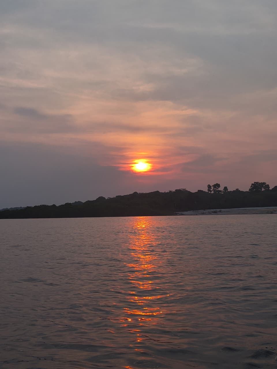 Sol se pondo sobre uma ilha e uma praia do Rio Negro